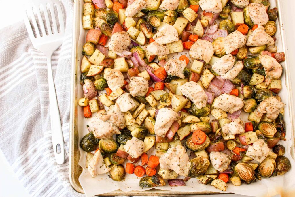 Chicken and brussels sprouts on a baking sheet.