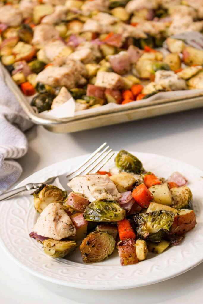 Chicken and brussels sprouts on a plate with a fork.